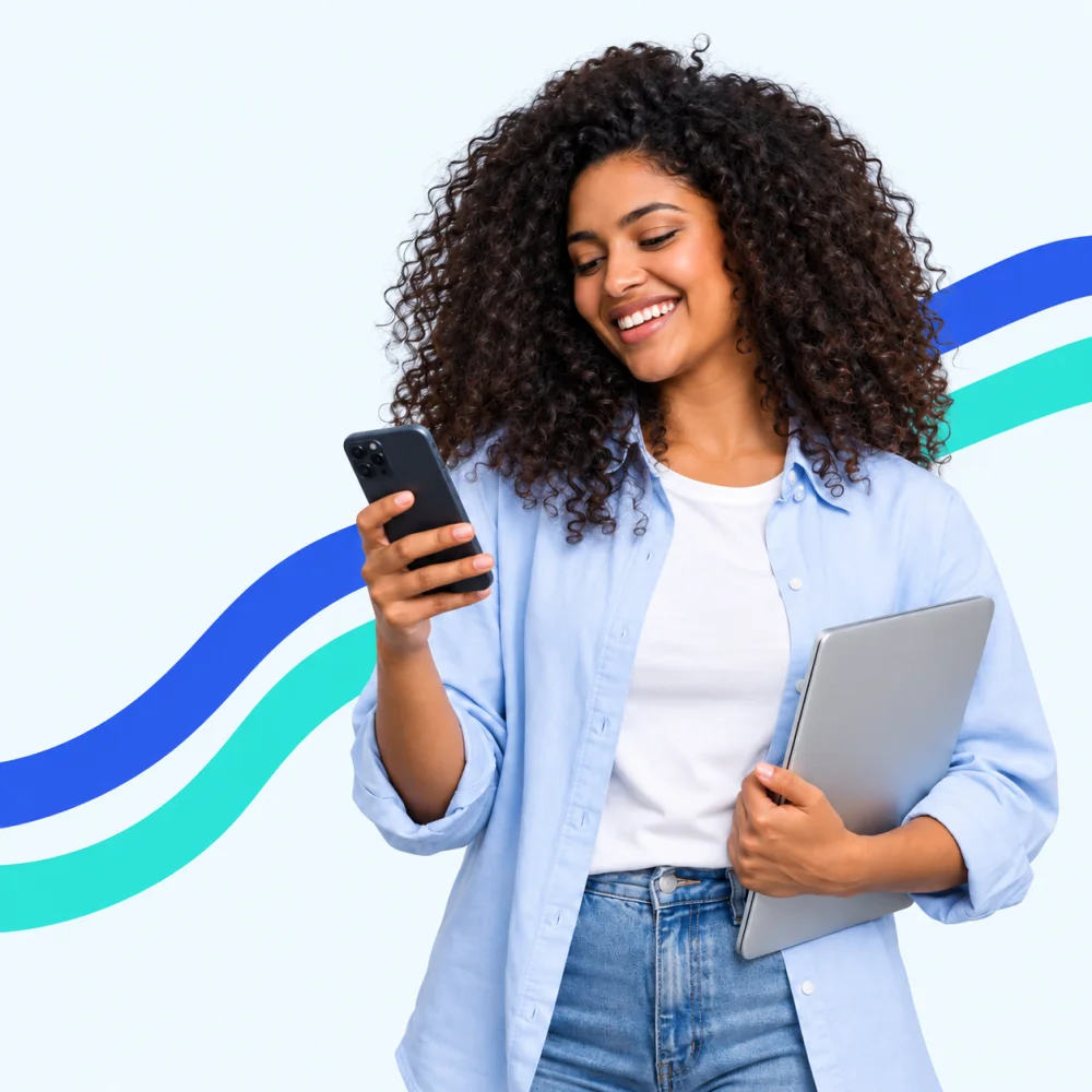 Mulher sorrindo ao usar o celular, com um notebook no braço